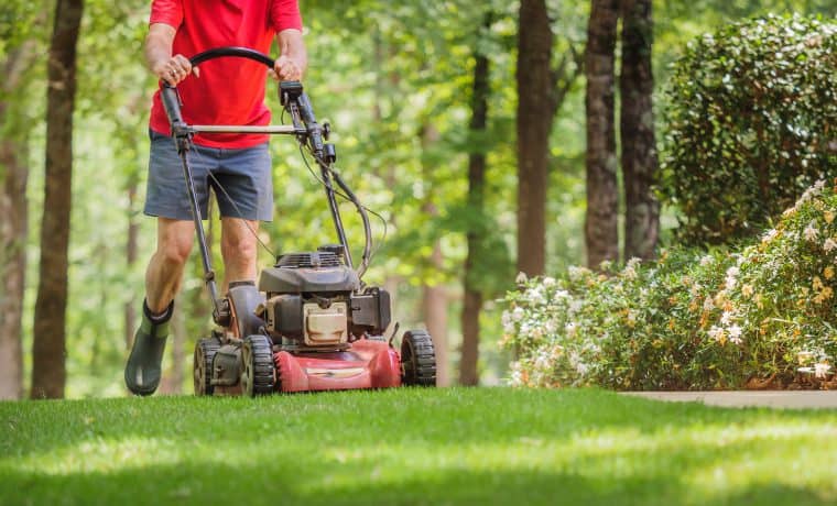 Mowing,Grass,With,A,Gas,Powered,Lawn,Mower.,Male,Landscaper tosaerba