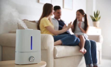 Modern,Air,Humidifier,And,Blurred,Family,On,Background purificatori d'aria